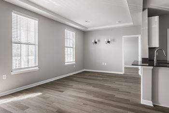 An empty living room with white walls and wood floors